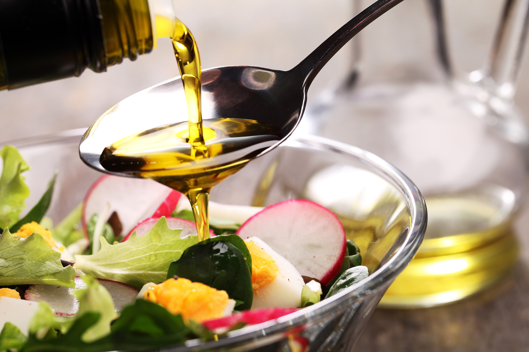 TRISYL®: the future for cooking oils Oil pouring on a spoon over a bowl of salad