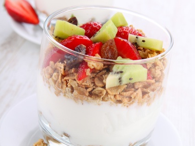 Yoghurt in a glass topped with cereals and frits