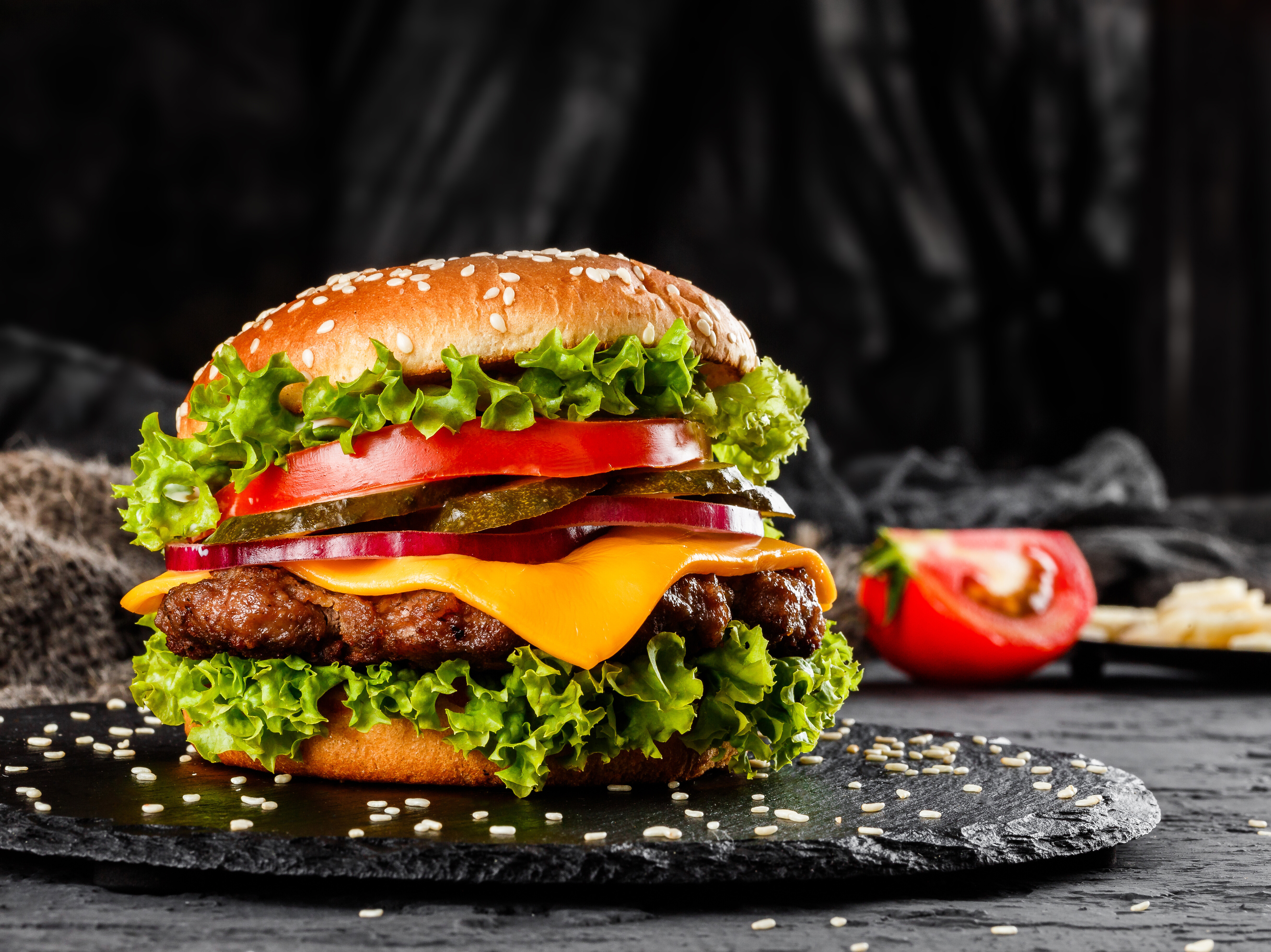 Innovative protein sources from insects and peas Burger with a patty, tomatoes, cheese, pickles, salad and ketchup