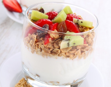 Yoghurt in a glass topped with cereals and frits