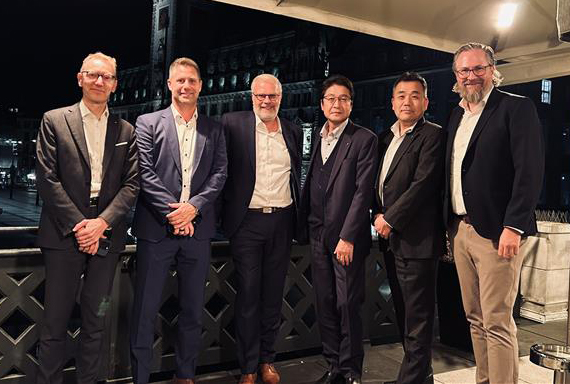 Daikin et Nordmann : 50 ans de partenariat Groupe de six hommes en costume le soir sur la terrasse d'un restaurant posant pour une photo de groupe.