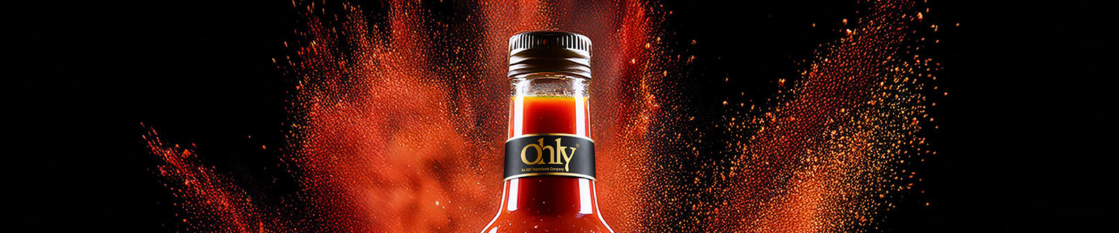 Bottle neck of a bottle with hot sauce and the ohly logo on it.
