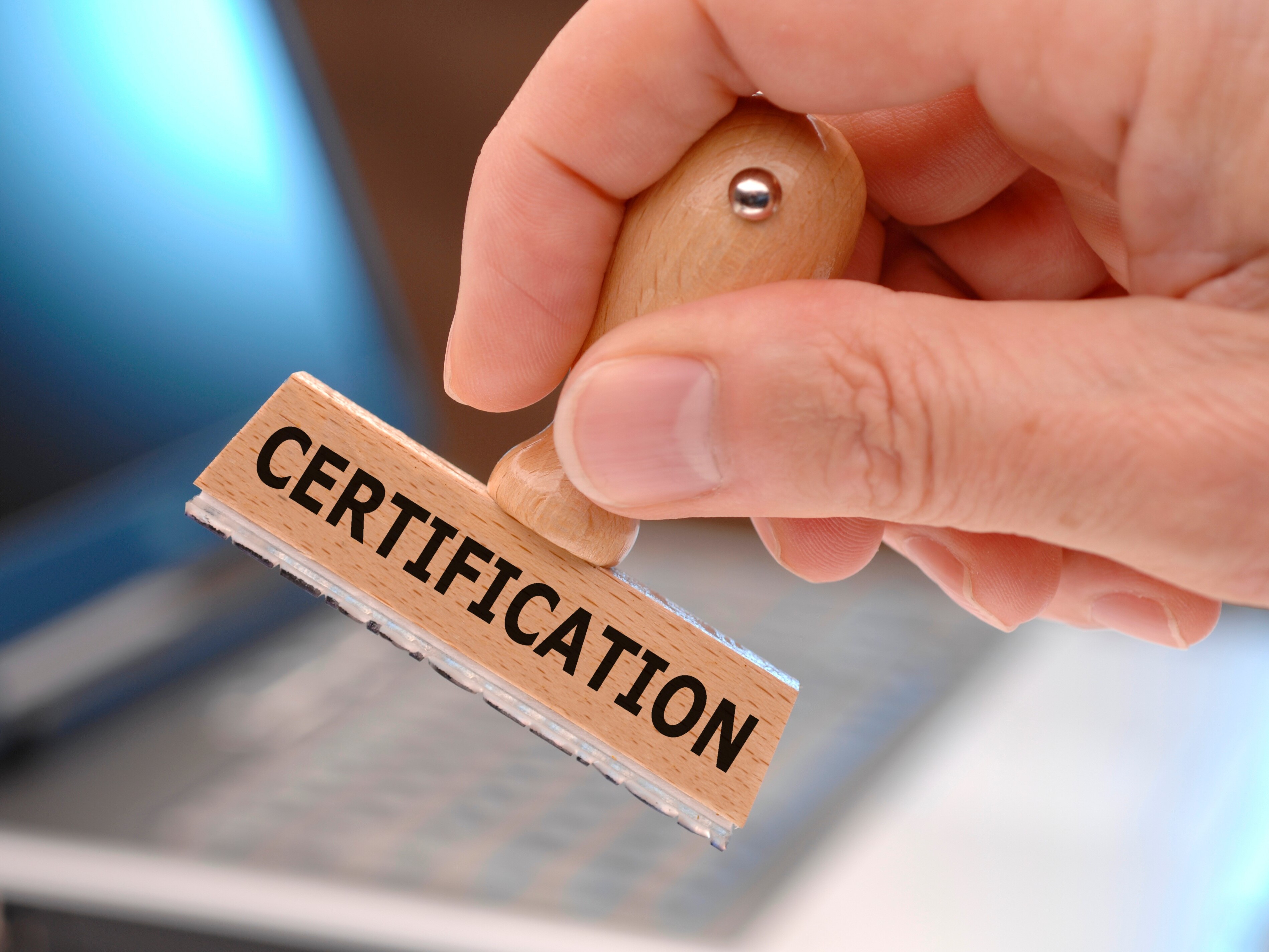 une main tenant un timbre avec la mention "Certification