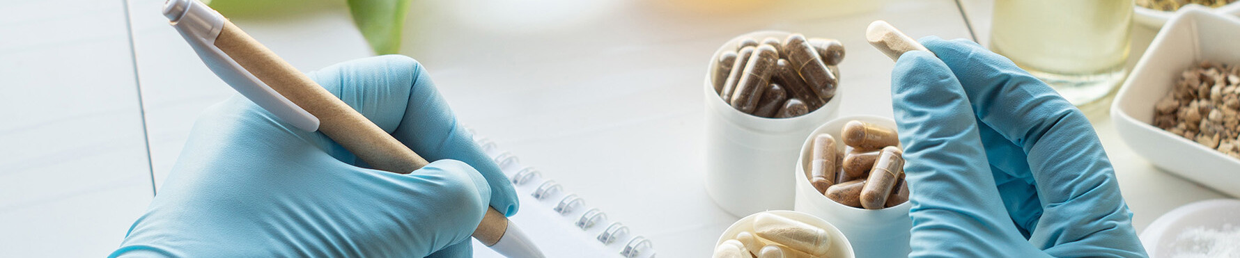 Soins de santé Mains couvertes de gants bleus tenant des capsules