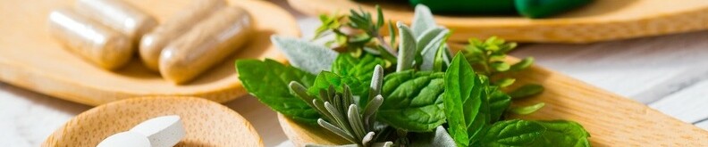 Health Care small wooden bowls filled with green herbs and tablets