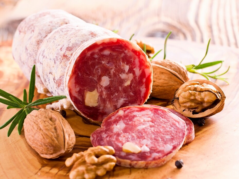 Bild von aufgeschnittener Salami und Walnüssen auf einem Holzbrett